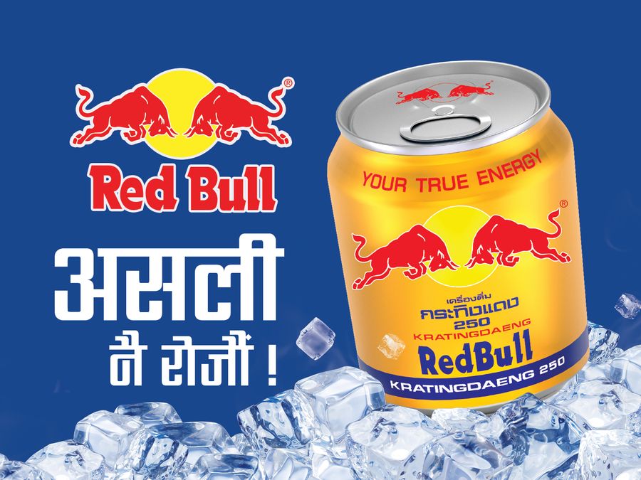 The Red Bull logo and a Nepali tagline beside a gold Red Bull can on ice